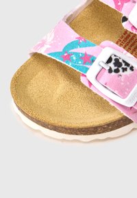 Ροζ υφασμάτινο σανδάλι με ρυθμιζόμενες αγκράφες, χρυσό ανάγλυφο πέλμα και βυσσινί σόλα φελλού με λευκή άκρη. Πολύχρωμα αστέρια και διακοσμητικά μοτίβα.