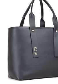 Zwarte tote bag van glad synthetisch leer, met twee handvatten, een rechthoekige vorm en een goudkleurig logo-accent met stikdetails.