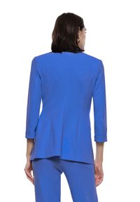 Blazer blu con maniche a tre quarti e polsini arrotolati, caratterizzato da una vestibilità sartoriale e un design elegante, realizzato in un tessuto liscio.