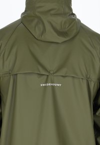 Grüne wasserdichte Jacke mit Kapuze, ausgestattet mit einem knöpfbaren Rücken und dem Markennamen "SWEDEMOUNT" in weißen Buchstaben. Glatte Textur.