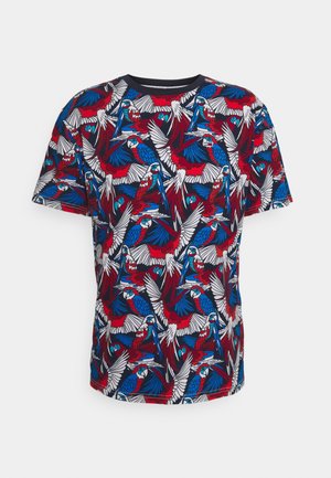 Koszulka z krótkim rękawem z wzorem wielokolorowego papugi w kolorach czerwonym, niebieskim i białym na ciemnoniebieskim tle. Wykonana z miękkiej tkaniny.