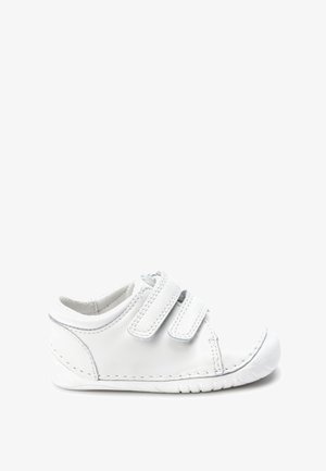 Valge nahast king, millel on kaks kinnitust Velcro-st, ümar varvas, tekstuuriga tald ja äärte ääres õmmeldud detailid.