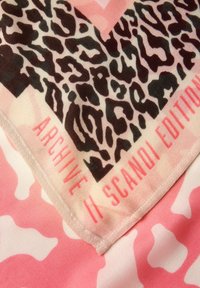 Écharpe multicolore présentant un motif léopard en nuances de brun et noir avec des accents roses. Comprend le texte "ARCHIVE II SCANDI EDITION".