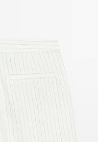White linen trousers with a pinstripe pattern, featuring a single back pocket and a stitched waistband.