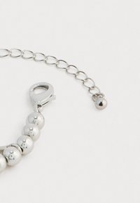 Ασημένιο βραχιόλι με χάντρες και ρυθμιζόμενη αλυσίδα με κούμπωμα από αστακό σε απλό λευκό φόντο.