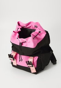 Svart och rosa ryggsäck med dragsko på toppen, rosa detaljer på framremmarna och en texturerad tygfinish. Justerbara remmar på baksidan.