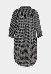 Robe noire et blanche à manches longues avec motif géométrique de maillons, coupe ample et ourlet arrondi, vue de dos.