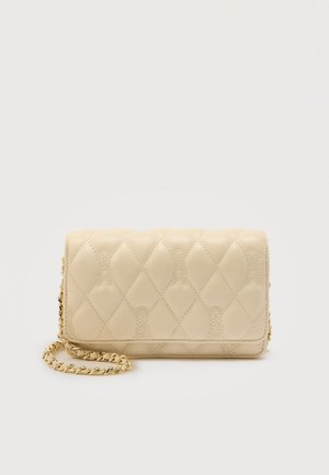 Beige gewatteerde leren clutch met diamantstiksels en gouden kettingriem, afgebeeld tegen een eenvoudige lichte achtergrond.