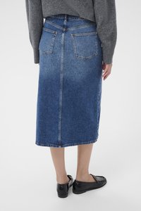 Denim midi-hame sinisessä, jossa on pieni haalistuma, suora leikkaus, takataskut ja viimeistelty helma, yhdistettynä mustiin loafereihin.