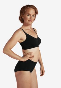 Svart bh och högmidjad underklädesset, tillverkat av mjukt tyg med justerbara axelband och slät yta. Enkel, sömlös design.