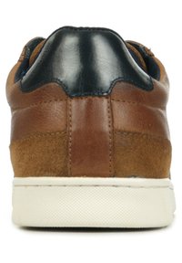 Baskets en cuir marron et en daim avec un accent en cuir noir sur le talon, semelle texturée et une semelle extérieure en caoutchouc blanc. Design épuré et minimal.