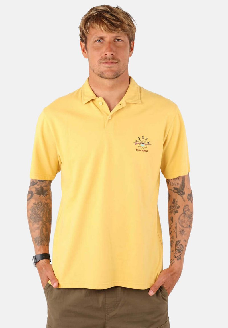 Polo shirt jaune en coton avec un col, des manches courtes et un logo sur le devant. Texture lisse et coupe décontractée.