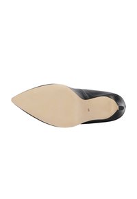 Musta nahkainen korkokenkä, jossa on terävä kärki. Silkinsuojainen pinta ja beige ulkopohja, jossa on kokoleima. Klassinen muotoilu ilman koristeita.