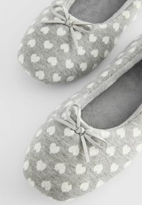 Grijze ballerina slippers van zacht stof, met een hartpatroon in het wit, een ronde neus en een decoratieve strik aan de voorkant.