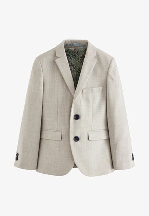 Hellbeige Blazer aus strukturiertem Stoff, mit zwei dunklen Knöpfen, einer linken Brusttasche und einem grün gemusterten Innenfutter.