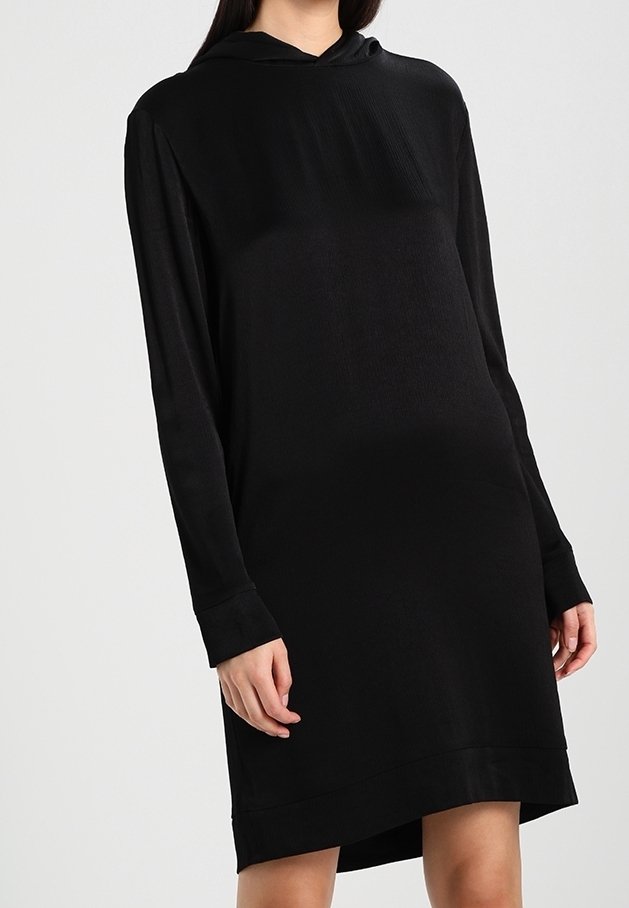 Abito nero con cappuccio realizzato in morbido materiale, dotato di maniche lunghe, vestibilità rilassata e orlo che arriva appena sopra il ginocchio.
