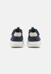 Navy suede and mesh sneakers with a white sole, featuring a blue heel loop and light grey accents at the back, showcasing a modern design.
