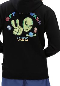 Sudadera negra con un gráfico colorido de un alienígena, un símbolo de paz y el texto "OFF THE WALL" y "vans", junto con motivos juguetones adicionales.