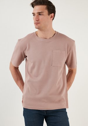 Tricou ribbed roz deschis, cu guler rotund și mâneci scurte, având o buzunar pe piept și o croială lejeră.