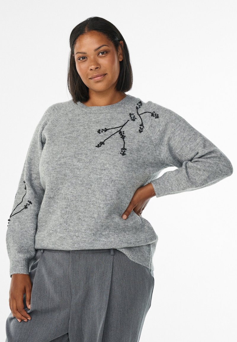 Hallhalli hall sweater tekstureeritud kootud mustriga, millel on mustad lillemustrid õlal. Pika varrukaga ja lahtise, juhusliku lõikega.