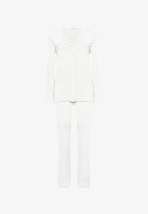 Bílý dvoudílný set domácího oblečení zahrnující košili na knoflíky s krajkovými detaily na ramenou a dlouhými rukávy, doplněný o úzké kalhoty.