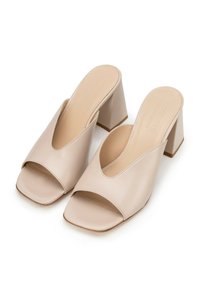 Mule aperti in pelle beige con design a V, ampia fascia anteriore e tacco a blocco. Texture liscia con accenti minimi.