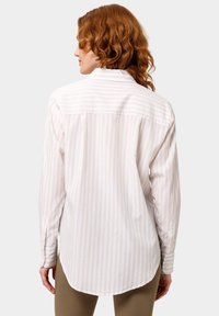 Langsleeve shirt van lichtgewicht stof, met verticale witte en lichtroze strepen, een gebogen zoom en knoopsluiting bij de manchetten.