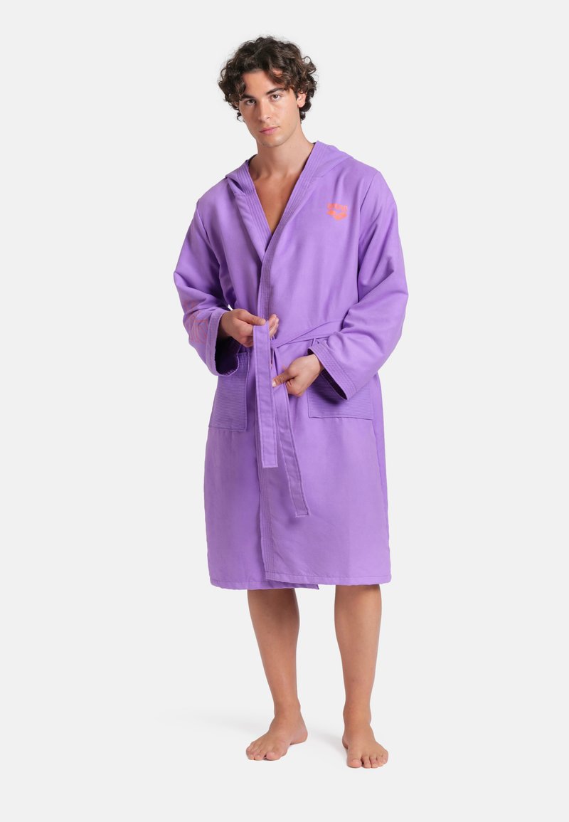 Accappatoio viola con cappuccio, realizzato in tessuto morbido. Presenta una cintura in vita, due tasche frontali e un piccolo logo ricamato sul petto.