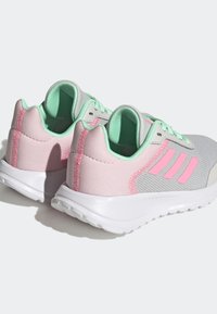 Scarpe sportive grigie con accenti rosa e menta. Realizzate in rete e materiale sintetico. Presentano una suola bianca e tre strisce diagonali.
