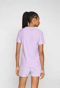 Lichtpaarse t-shirt gemaakt van zachte stof, met een klassieke ronde hals en korte mouwen, gecombineerd met bijpassende shorts.