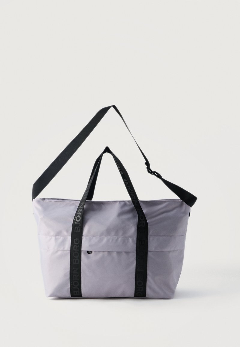 Τσάντα ώμου σε ανοιχτό μωβ χρώμα με μαύρο ρυθμιζόμενο ιμάντα ώμου και μαύρες λαβές, εκτυπωμένες με το λογότυπο "BJÖRN BORG", μπροστινή τσέπη με φερμουάρ.