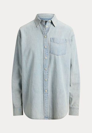 Chemise en denim bleu clair à boutons, manches longues, poche poitrine côté gauche, et ourlet arrondi.