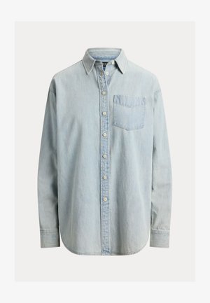 Chemise en denim bleu clair à boutons, manches longues, poche poitrine côté gauche, et ourlet arrondi.