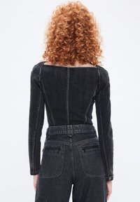 Sort denim langærmet top med firkantet udskæring, der har kontrasterende syninger og et tætsiddende design, der går til taljen.