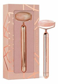 Rolka do twarzy z różowego kwarcu z metalicznym uchwytem w kolorze różowego złota. Zapakowana w pudełko o geometrycznym wzorze z różowym tłem i złotymi akcentami.