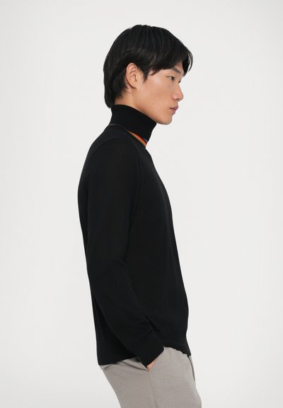 Crna turtleneck pulover majica s prilagođenim dizajnom i kontrastnim duginim ovratnikom. Mekana tekstura, dugi rukavi i jednostavno tijelo.
