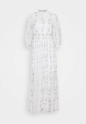 Robe longue blanche transparente avec motif floral, manches trois-quarts bouffantes, taille ajustée et jupon intérieur.
