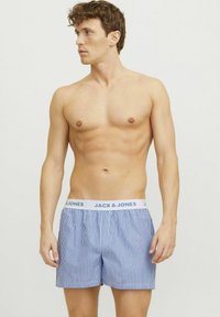 Boxers rayés bleus en coton avec une taille élastique portant le nom de la marque "JACK & JONES" en lettres bleu clair.