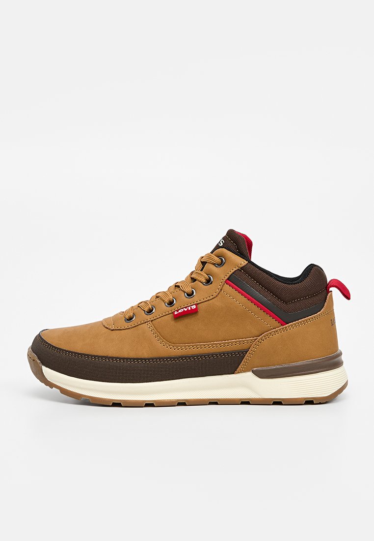 Sneaker in suede e tessuto marrone con suola beige chiaro, accenti rossi e marroni scuri, e design con lacci. Presenta il logo di lato.