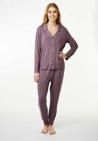 Violetti pyjama-asuste, johon kuuluu napillinen paita, jossa on kaulus, sekä yhteensopivat housut. Molemmissa on pieniä, hienovaraisia kuvioita ja hihansuita.
