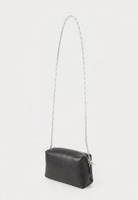 Black leather bag with a rectangular shape, zip closure, and a long silver chain strap, featuring a textured surface for a tactile feel.