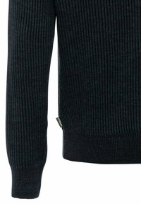 Pull côtelé bleu marine foncé avec tissu texturé et une petite étiquette sur le côté. Manches longues avec poignets ajustés.