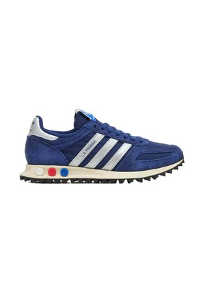 Sneaker Adidas L.A. Trainer blu con strisce bianche, tomaia in suede e mesh, suola ammortizzata con accenti circolari rossi, bianchi e blu, e suola esterna testurizzata.