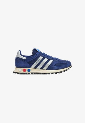 Sneaker Adidas L.A. Trainer blu con strisce bianche, tomaia in suede e mesh, suola ammortizzata con accenti circolari rossi, bianchi e blu, e suola esterna testurizzata.