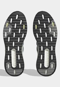 Sorte og grå sneakersåler med hvid BOOST-dæmpning synlig gennem rektangulære udskæringer, designet til greb og komfort.