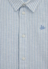 Světlomodrá a bíle pruhovaná košile z lnu s límečkem na knoflíky, plastovými knoflíky a malým modrým vyšívaným detailem.