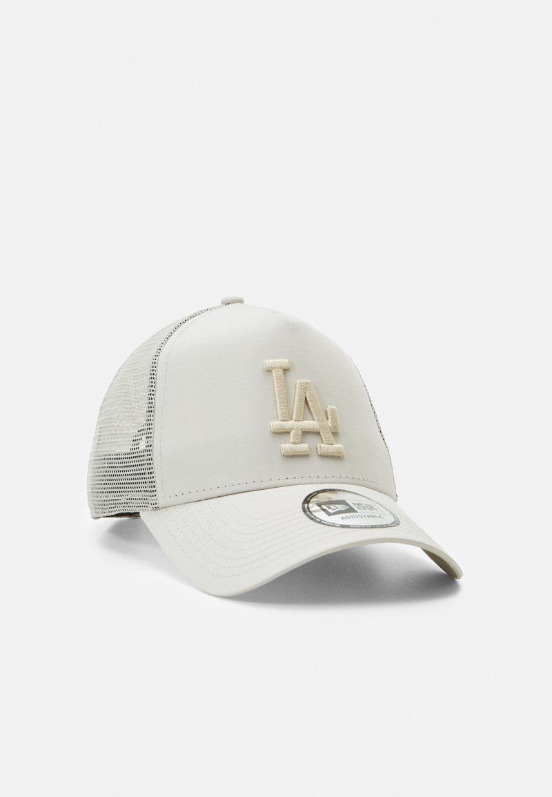 Light beige trucker cap with mesh sides, featuring a raised LA logo in matching color. Curved brim and adjustable snapback closure.