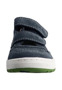 Blauer Wildlederschuh mit zwei Klettverschlüssen, weißer Gummisohle und grünem Akzent an der Unterseite. Strukturierte Oberseite mit Nahtdetails.