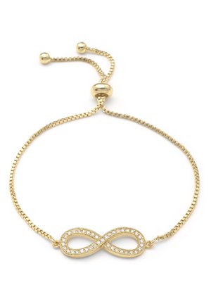 Bracelet chaîne réglable en or avec un pendentif symbole de l'infini incrusté de petites pierres précieuses transparentes sur fond blanc.