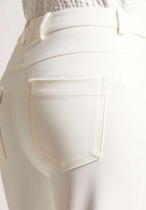 Weiße Denim-Jeans mit einer taillierten Passform, ausgestattet mit zwei Gesäßtaschen, subtilen Nähdetails und einer glatten Textur.